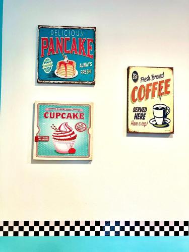 three signs on a wall with a cupcake and coffee at Happy Days On The Lake! in Viverone