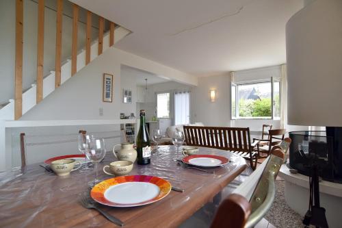 - une table à manger avec des assiettes et des verres à vin dans l'établissement Hurlevent - Maison vue mer, à Fréhel