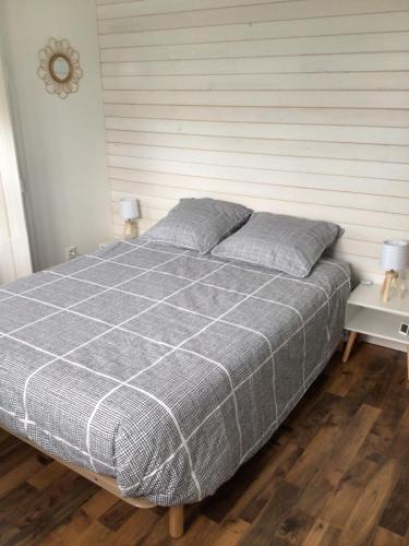 une chambre avec un lit avec une couverture à carreaux dans l'établissement La Tournerie de Valis, à Clairvaux-les-Lacs