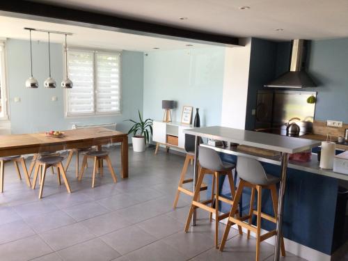 une cuisine avec une table et des chaises dans une pièce dans l'établissement La Tournerie de Valis, à Clairvaux-les-Lacs