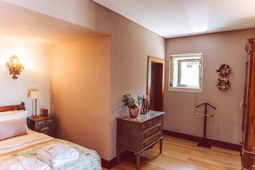 a bedroom with a bed and a dresser and a window at Quinta do Monteverde in Viana do Castelo