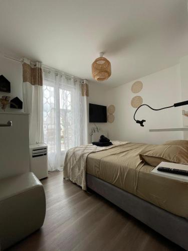 une chambre avec un lit et une grande fenêtre dans l'établissement Charmante Maison Piscine Privée, à Vert-Saint-Denis