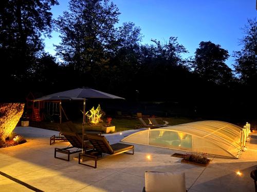 a patio with a tent and a table and chairs at Gîte Au Moulin de Bougnon Calme et Dépaysement en Haute-Saône in Bougnon