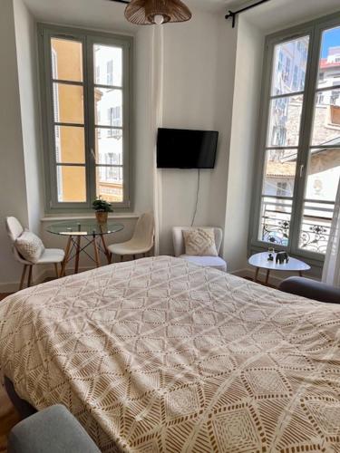 une chambre avec un grand lit et deux fenêtres dans l'établissement Studio Moderne, Centre Nice, à Nice