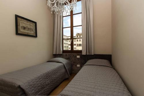 a bedroom with two beds and a window at Maison Alighieri in Florence