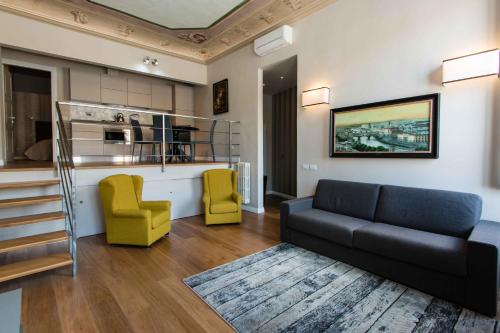 uma sala de estar com um sofá e cadeiras amarelas em Maison Alighieri em Florença