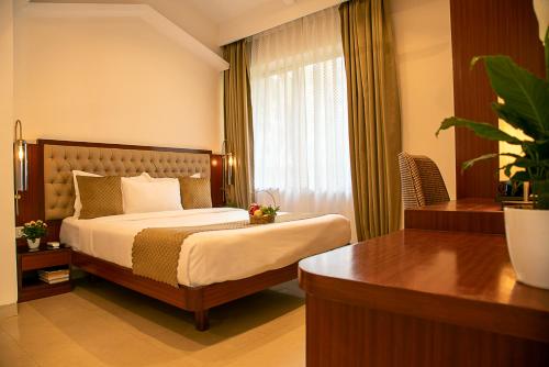 a hotel room with a bed and a desk at TreeHouse Stamp in Colva
