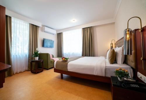 a hotel room with a large bed and a chair at TreeHouse Stamp in Colva