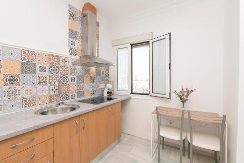 eine Küche mit Spüle und Fenster in der Unterkunft Verano en Chiclana in Chiclana de la Frontera