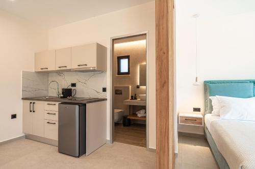 Una habitación con cocina y un dormitorio con cama. en Aetheria Suites, en Parga