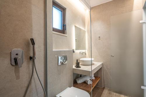 a bathroom with a toilet and a sink and a shower at Aetheria Suites in Parga