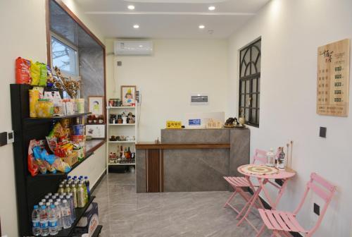 una stanza con bancone e tavolo e sedie di Harbin Qiju Hotel Taiping International Airport a Wujia