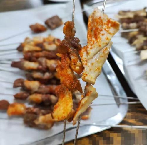 a plate of food with food on a stick at Harbin Qiju Hotel Taiping International Airport in Wujia