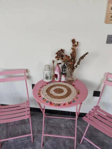 a pink table with two pink chairs and a table with at Harbin Qiju Hotel Taiping International Airport in Wujia