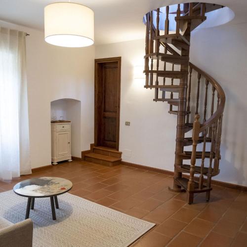 a living room with a wooden spiral staircase at Assisi Villa Simi in Petrignano