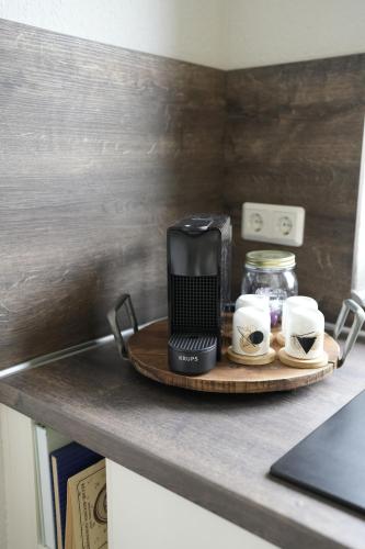 a coffee maker and two cups on a tray on a counter at lantliv in Wiesmoor