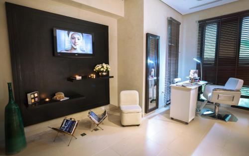 a living room with a tv on a black wall at Mövenpick Hotel Gammarth Tunis in Gammarth