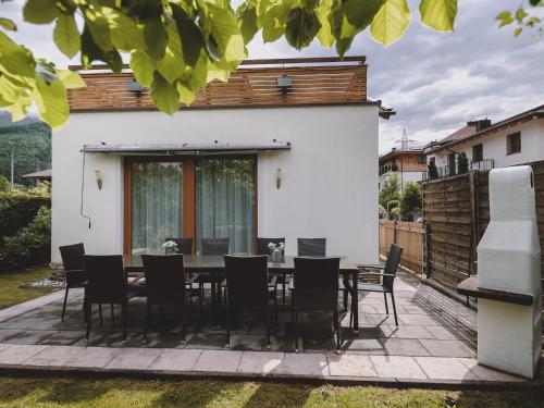 a dining room with a table and chairs on a patio at Chalet Naila by we rent in Bruck an der Großglocknerstraße