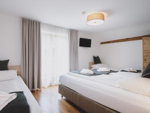 a bedroom with two beds and a large window at Chalet Naila by we rent in Bruck an der Großglocknerstraße
