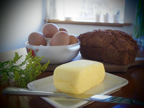a table with a bowl of eggs and a loaf of bread at Iris Cottage in Ráistín