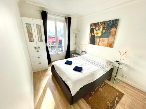une chambre avec un lit et un tableau au mur dans l'établissement Lovely Montmartre apartment, à Paris