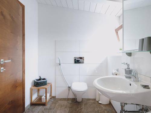 a white bathroom with a sink and a toilet at Chalet Naila by we rent in Bruck an der Großglocknerstraße