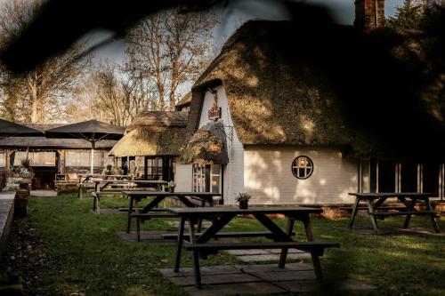 a group of picnic tables in front of a thatched building at The Pilgrim Inn in Southampton