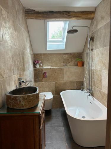 une salle de bain avec une baignoire, des toilettes et un lavabo dans l'établissement Moulin Les Riaux, à Châtillon-sur-Indre