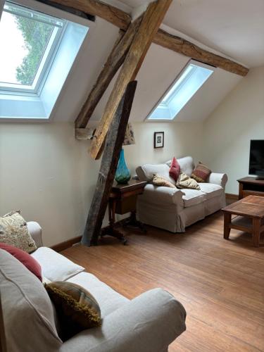 - un salon avec deux canapés et deux fenêtres dans l'établissement Moulin Les Riaux, à Châtillon-sur-Indre