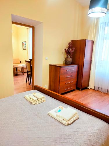 a bedroom with a mirror and a dresser with towels on a bed at APARTAMENT PLAC KATEDRALNY in Tarnów