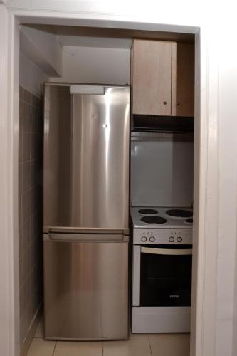 a kitchen with a stainless steel refrigerator and a stove at Διαμέρισμα δίπλα από την θάλασσα in Athens