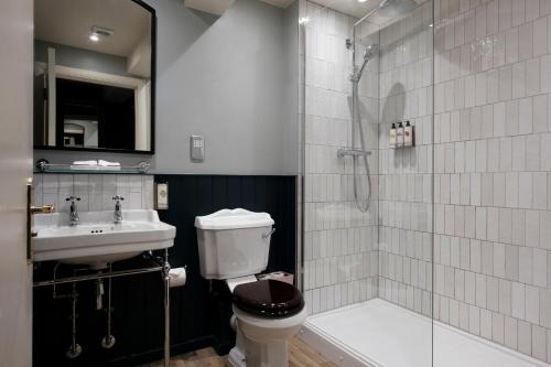a bathroom with a toilet and a sink and a shower at The Pilgrim Inn in Southampton