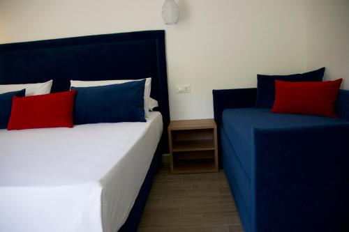 two beds with blue and red pillows in a room at Galaxy Rooms Tropea in Drapia