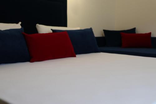 a bed with red and blue pillows on it at Galaxy Rooms Tropea in Drapia