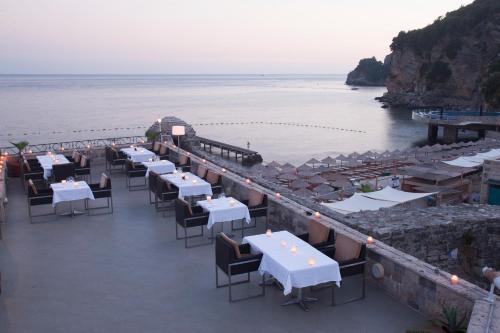 a restaurant on the beach with tables and chairs at Hotel Astoria in Budva