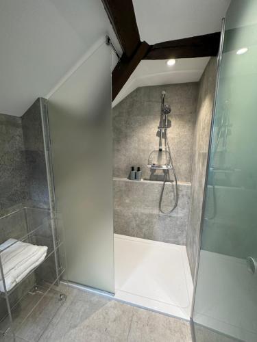 une salle de bain avec une douche avec une porte vitrée dans l'établissement L'Amour à la mer, à Honfleur