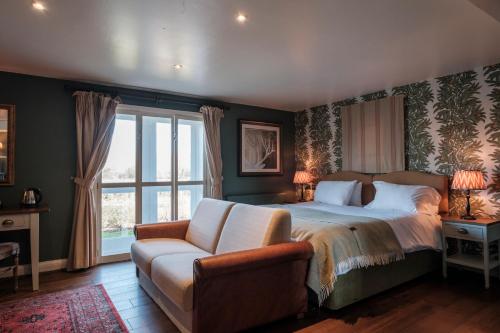 a bedroom with a bed and a couch and a window at The Pilgrim Inn in Southampton