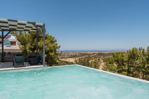 a swimming pool with a view of the ocean at Māat Villa in Heraklio Town