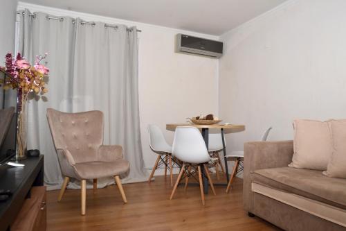 a living room with a couch and a table and chairs at Διαμέρισμα δίπλα από την θάλασσα in Athens