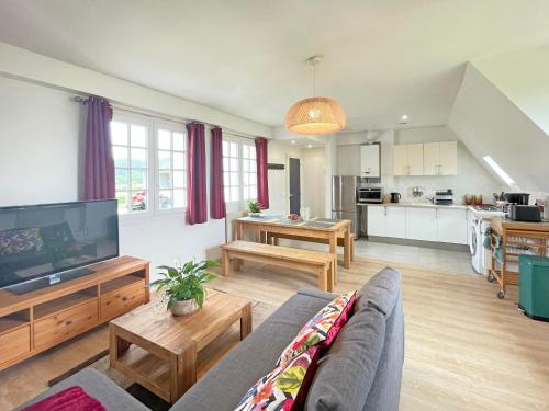 un salon avec un canapé et une télévision à écran plat dans l'établissement Tropical Cosy, à Saint-Martin-en-Bière