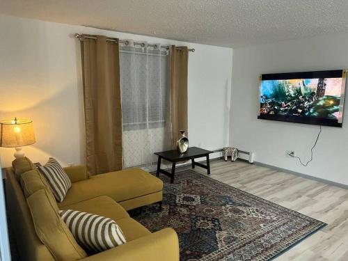 a living room with a couch and a tv on the wall at Beautiful downtown Anchorage 2 in Anchorage