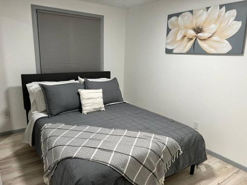 a bedroom with a bed with a flower painting on the wall at Beautiful downtown Anchorage 2 in Anchorage