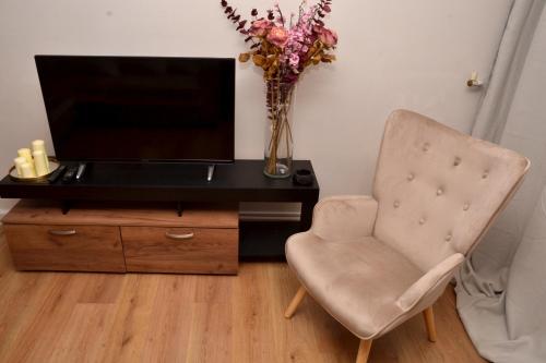 a desk with a vase of flowers and a chair at Διαμέρισμα δίπλα από την θάλασσα in Athens