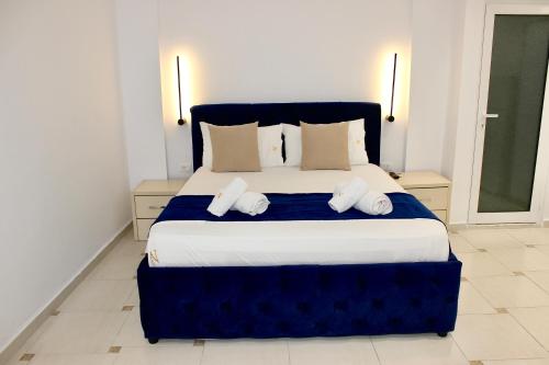 a bedroom with a blue and white bed with two pillows at Qeparo Napolon Complex in Qeparo