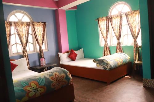 a room with two beds and two windows at Ice Land Homestay in Zuluk