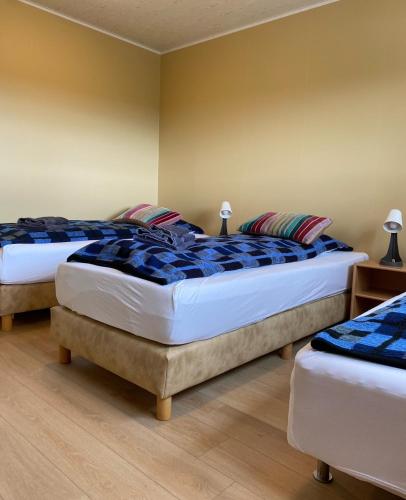 two beds in a bedroom with blue and white at Guesthouse Steinsholt in Steinsholt