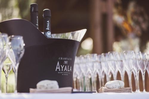 a bottle of wine sitting on a table next to glasses at Villa de l'Etang Blanc in Seignosse
