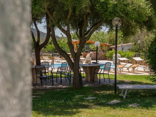 a group of chairs and a table and a tree at Luxury Home in Porto Rotondo in Cugnana