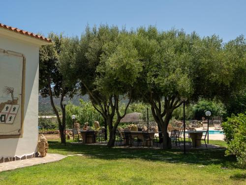 a garden with tables and trees and a pool at Luxury Home in Porto Rotondo in Cugnana