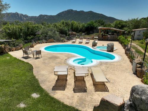 a pool with chaise lounge chairs and a swimming pool at Luxury Home in Porto Rotondo in Cugnana